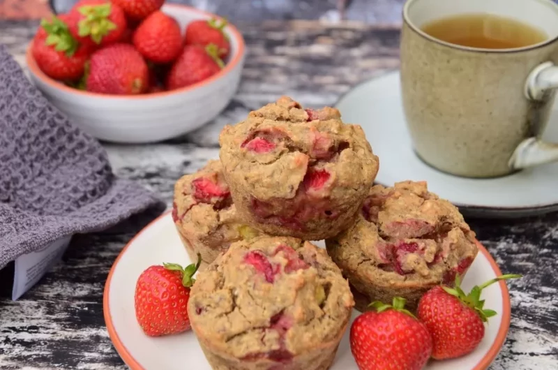 Gluten-free strawberry muffins on a plate with fresh strawberries.