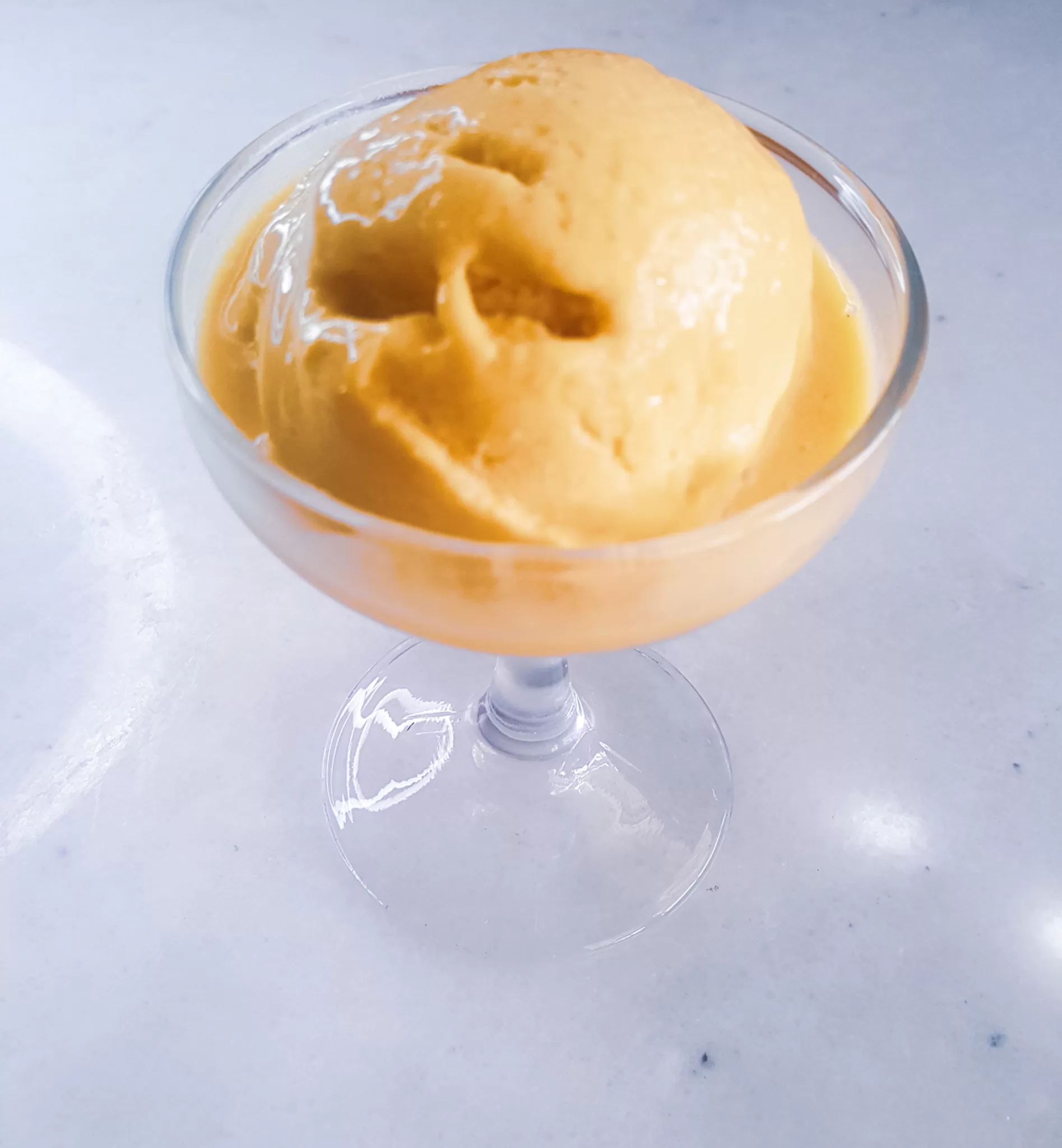 Vegan mango Ice cream in a dessert glass.