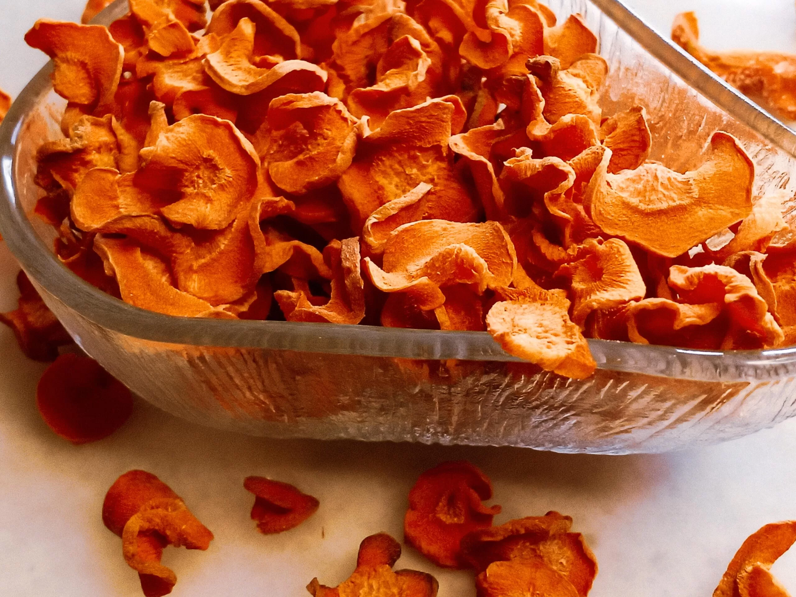 Dehydrated carrot chips in a bowl.