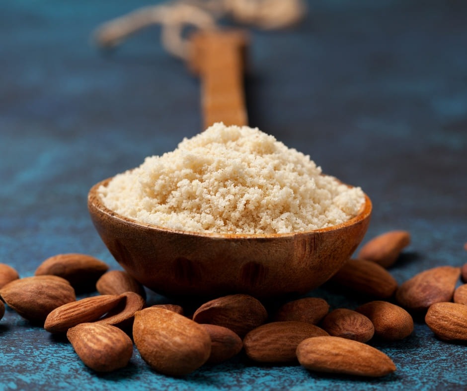Almond flour in a small wooden spoon.