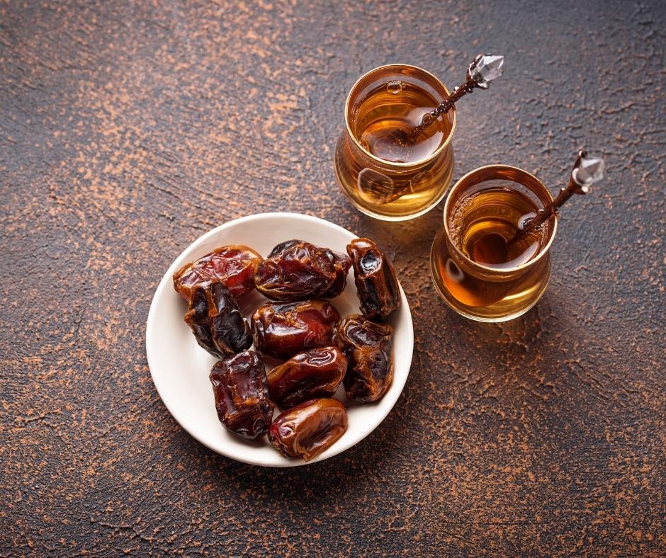 Dates on a plate with 2 jars of honey