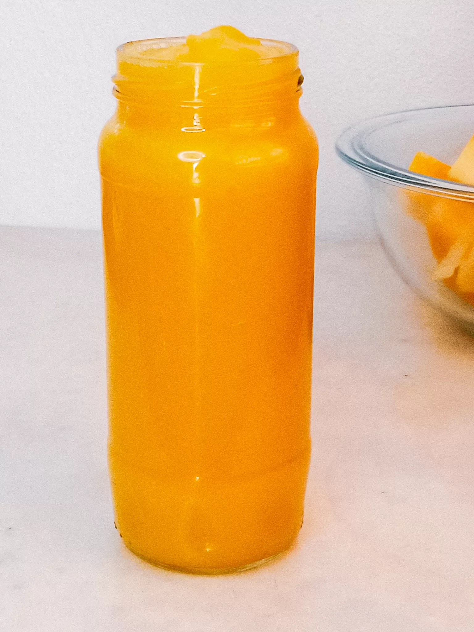 Homemade pumpkin puree in a jar and fresh diced pumpkin.