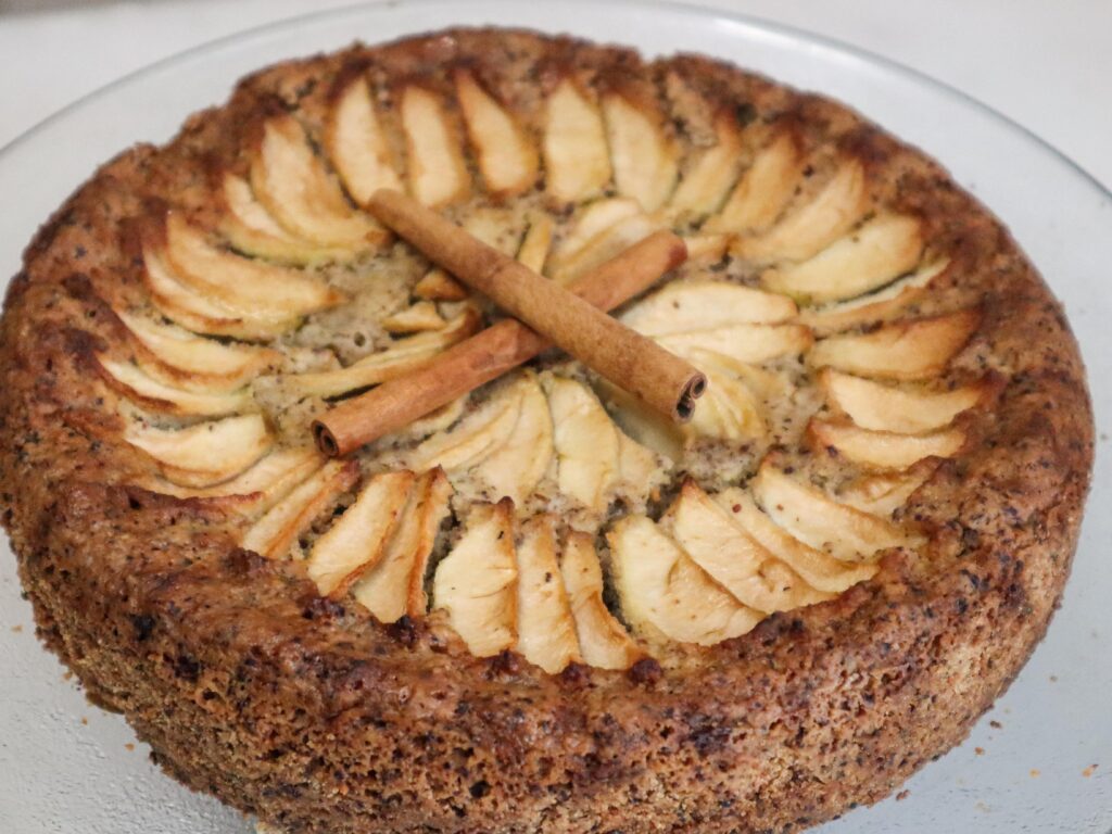 Hazelnut apple zucchini cake on a cake stand.