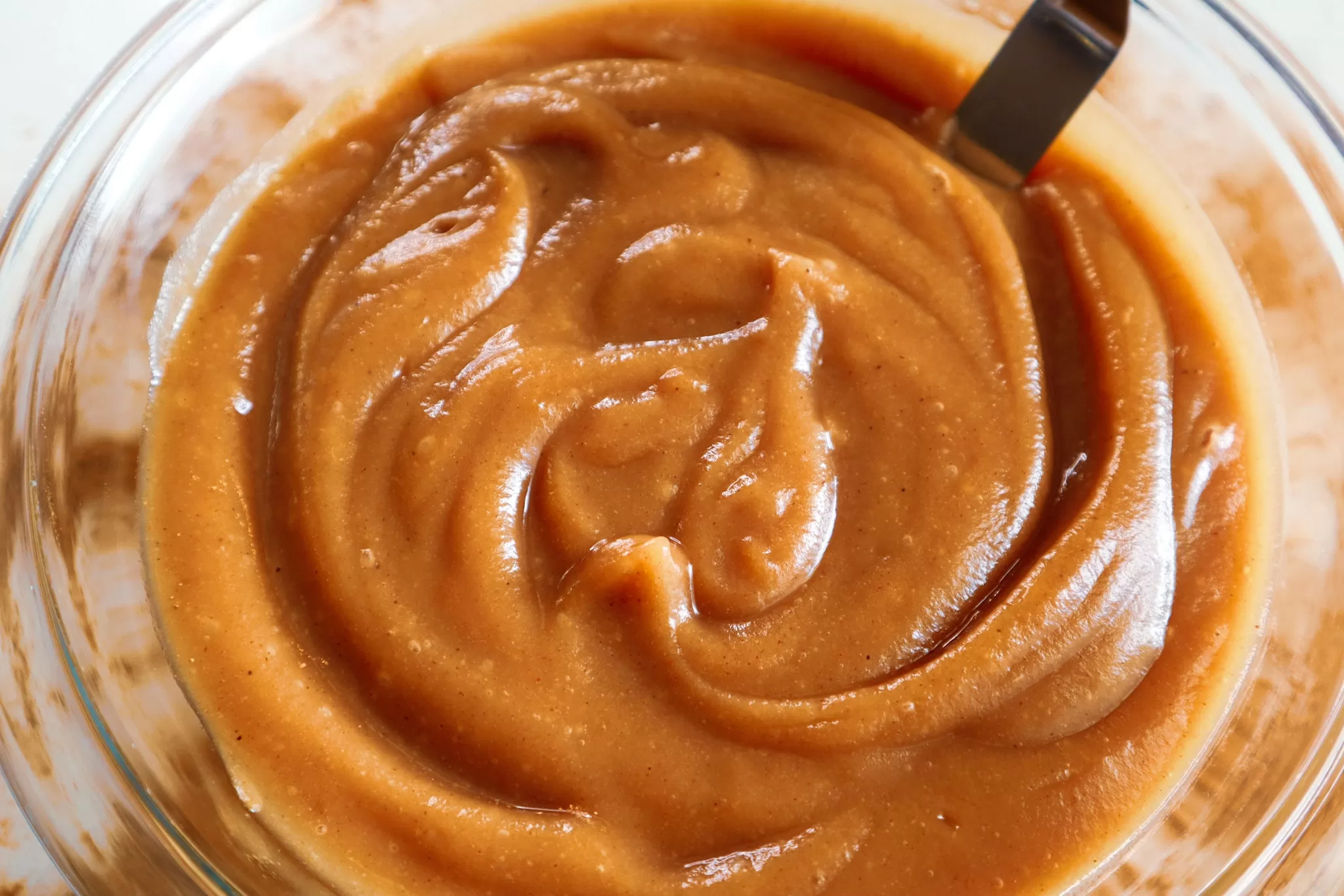 Slow cooker apple butter in a glass bowl.