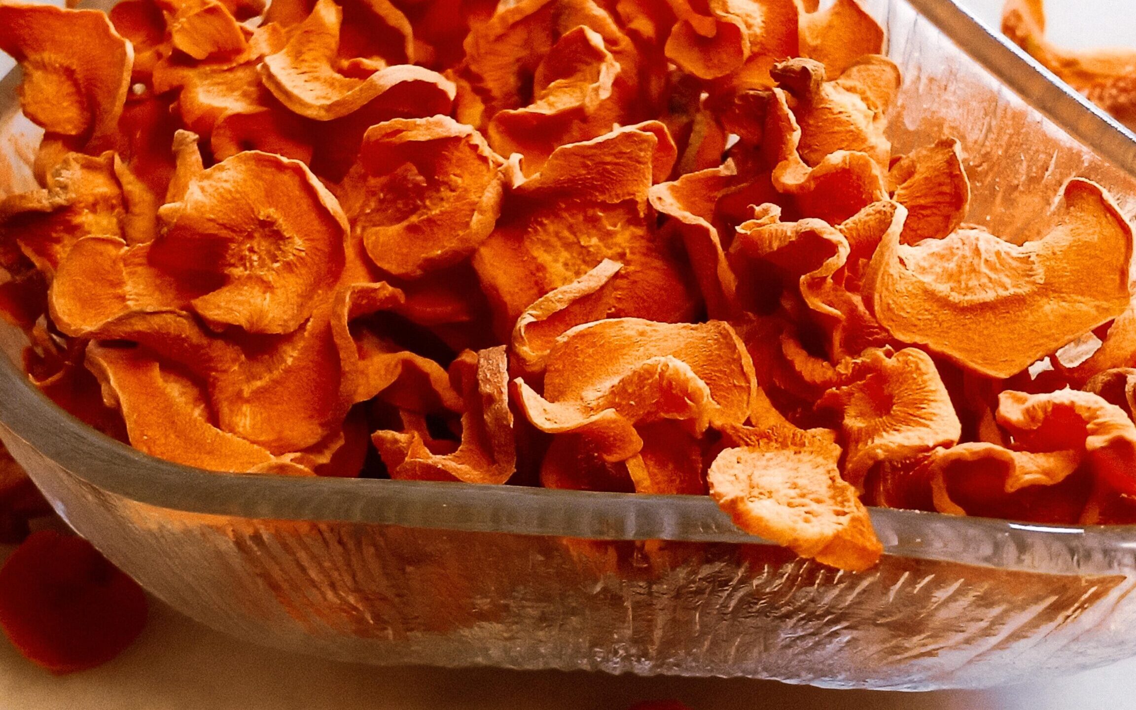 Dehydrated carrot chips in a bowl.
