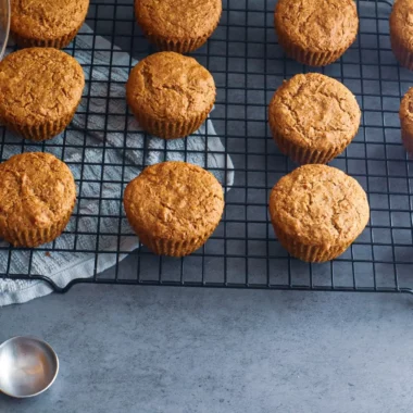 Paleo carrot cake muffins on a cooling rack.
