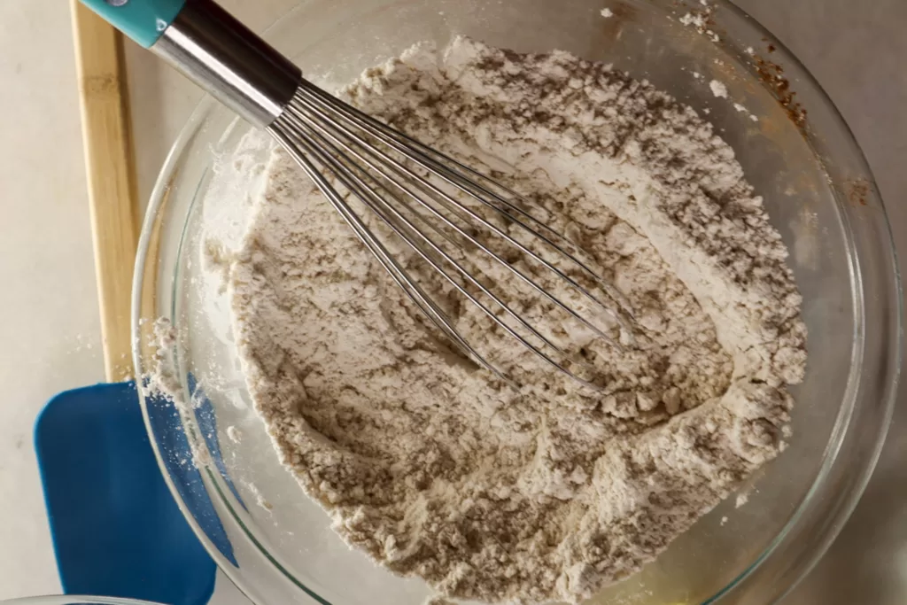 Dry ingredients being whisked in a large bowl.