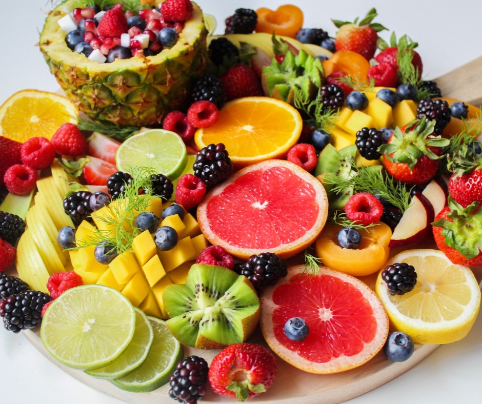 Fresh berries, kiwi, lime slices, lemons oranges and grapefruit arranged on a serving platter.