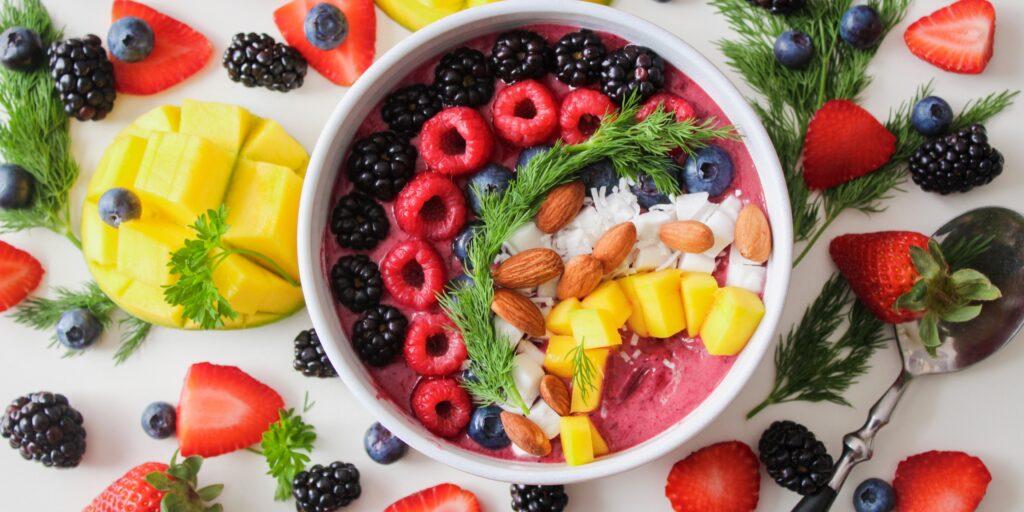 Fruit smoothie bowl surrounded by fruit.