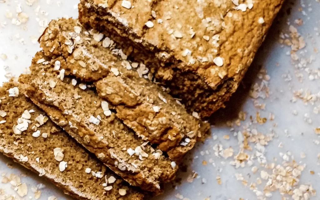 Sliced spiced oat flour bread on a tile.