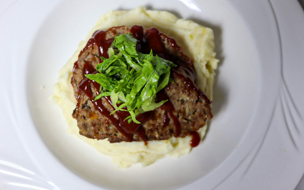 Gluten-free meatloaf with cranberry glaze served with pashed potatoes.