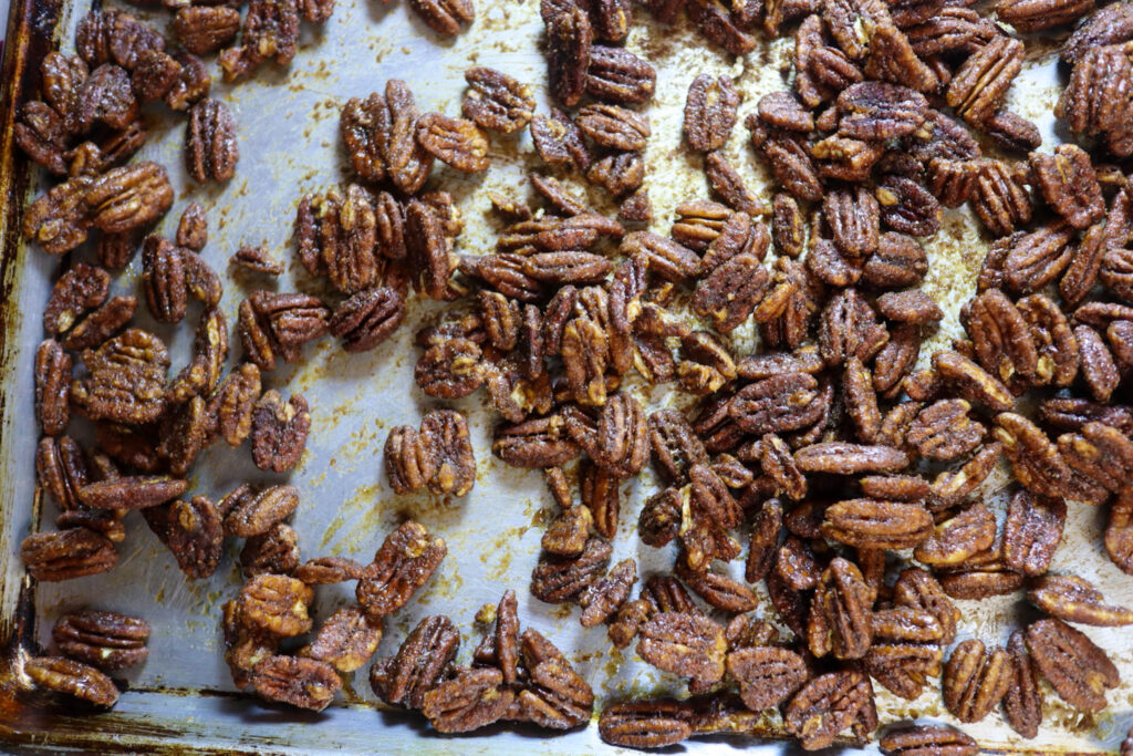 Spiced candied pecans on a baking sheet.