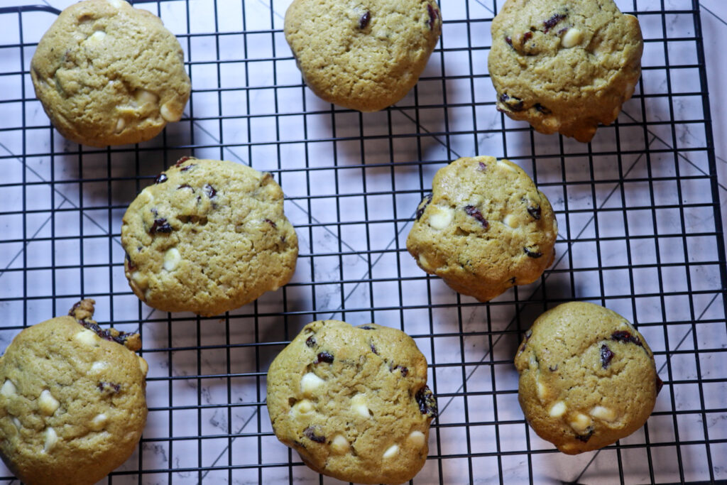 Gluten-free cranberry white chocolate chip cookies on a cooling rack.