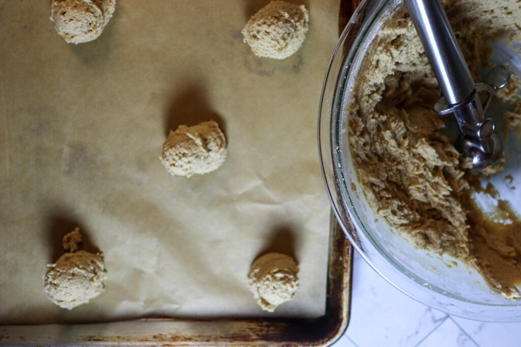 Scooping the cookies on a parchment-lined baking sheet.