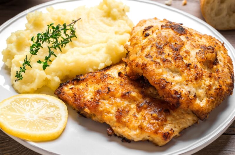 Mashed potatoes with fried chicken cutlets and lemon slices.