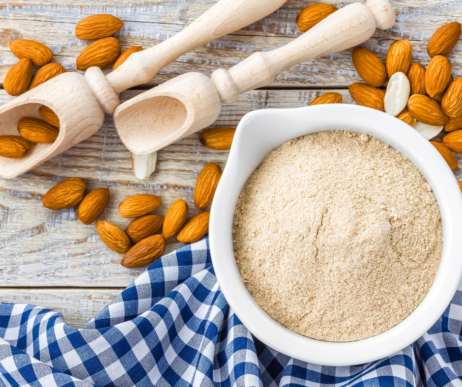 Almond flour in a bowl with raw whole almonds.