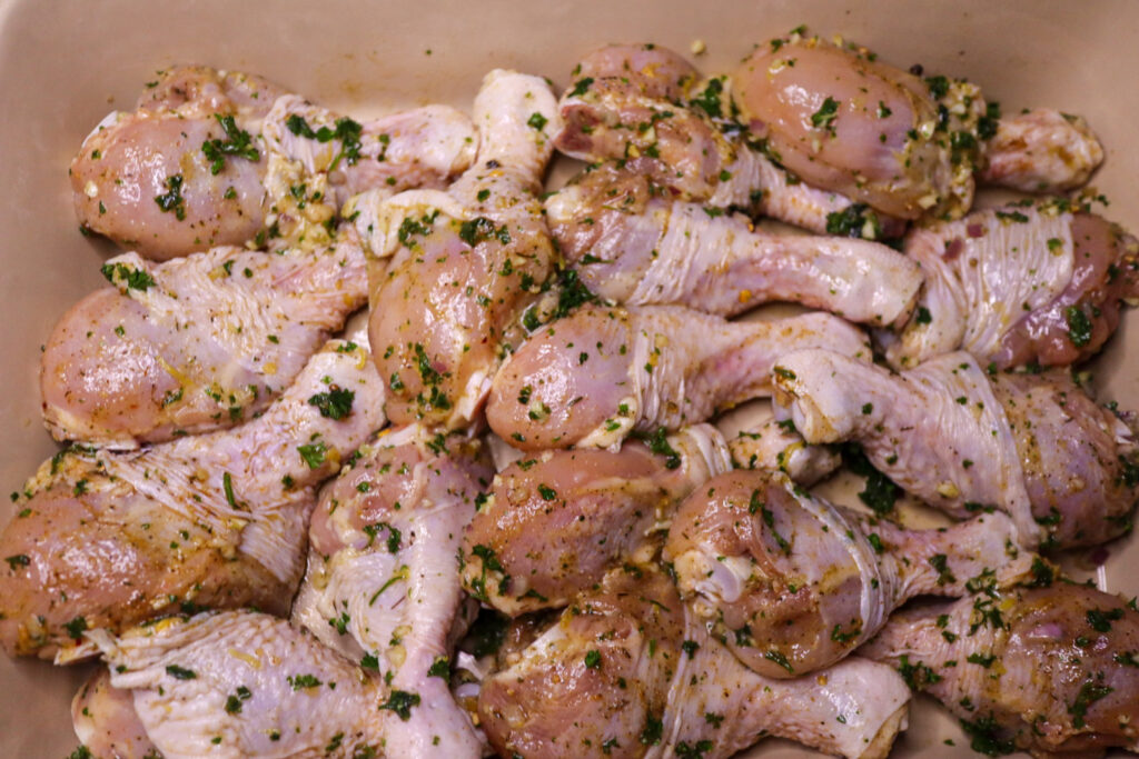Placing the chicken legs in a baking dish.