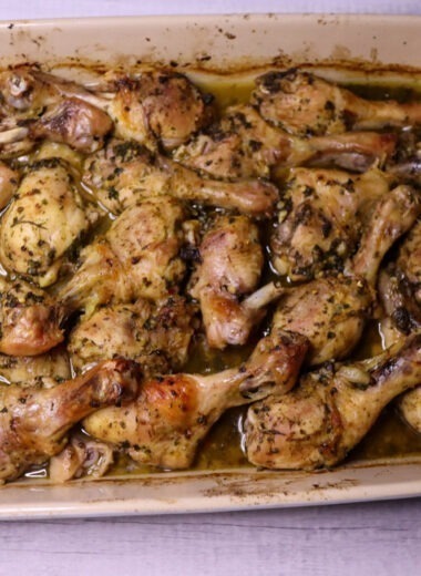 Baked lemon parsley chicken legs in a baking dish.
