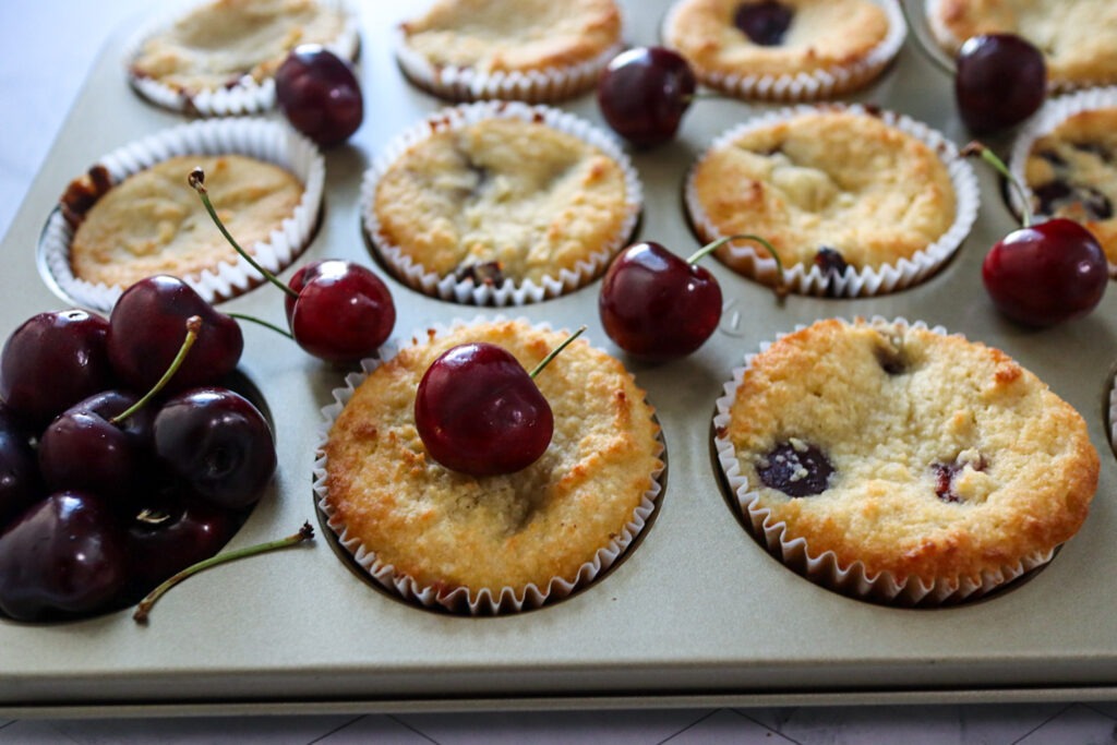 Keto Cherry Muffins garnished with fresh cherries.