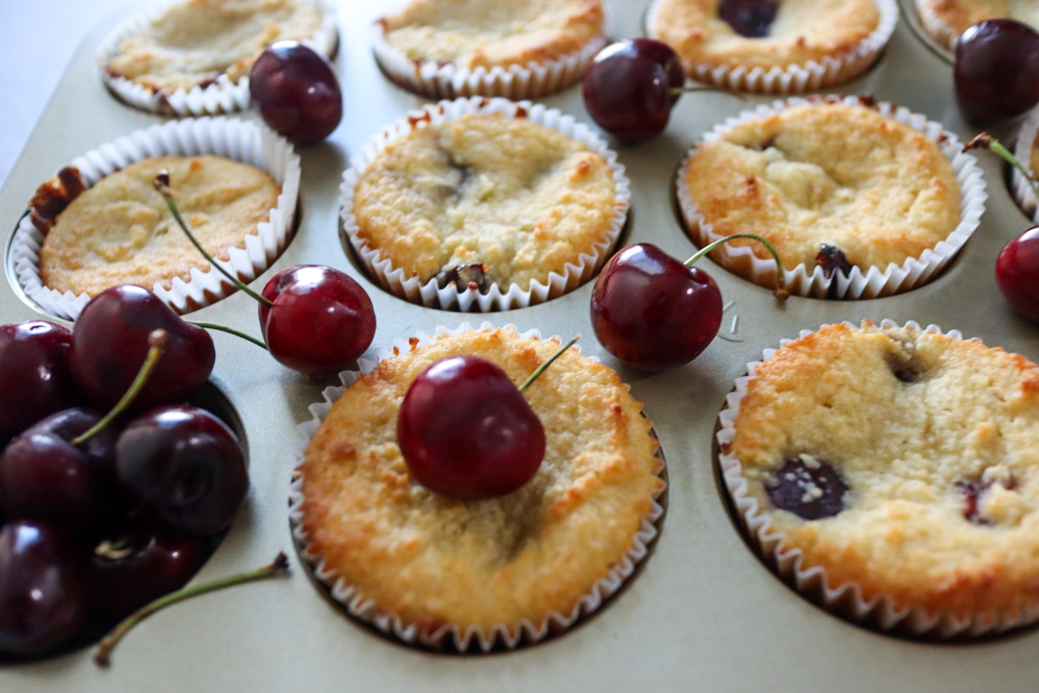Keto Cherry Muffins garnished with fresh cherries.