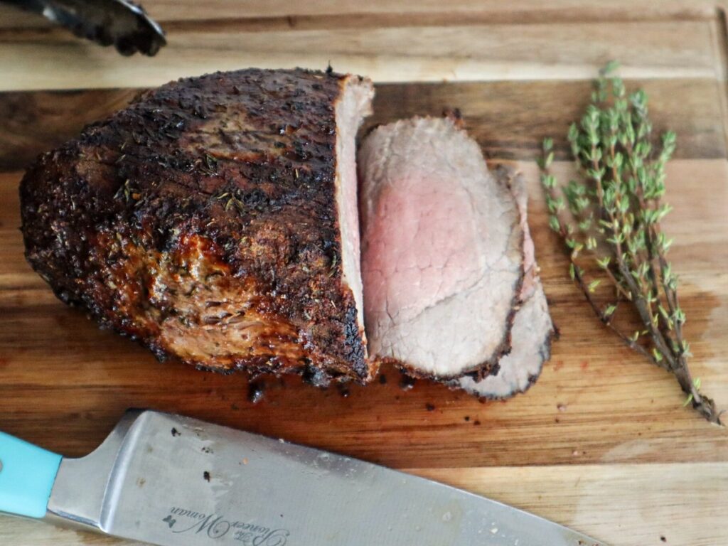 Air fryer roast beef on a cutting board.