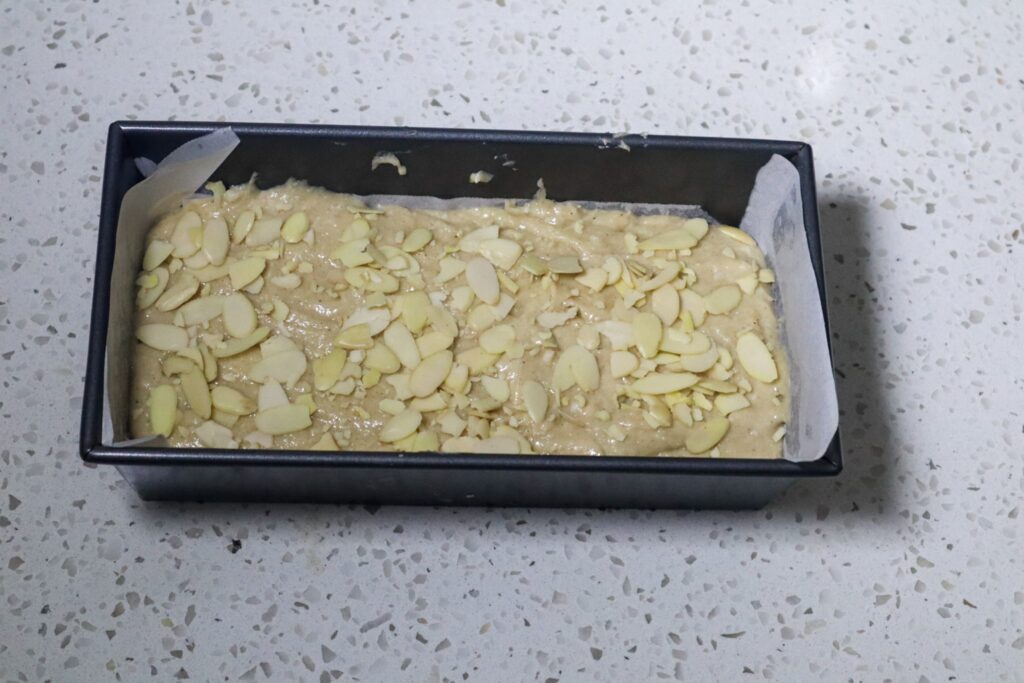 Topping the eggnog bread with sliced almonds.