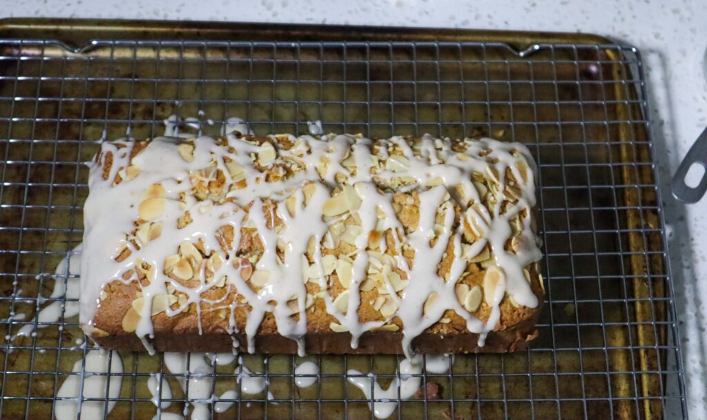 Drizzling the glaze on the eggnog bread.