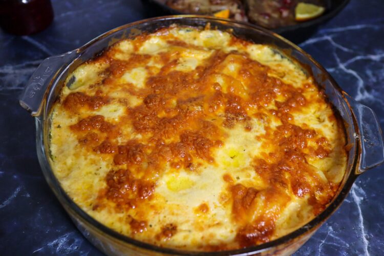 Scalloped potatoes with cranberry-glazed pork chops in the background.