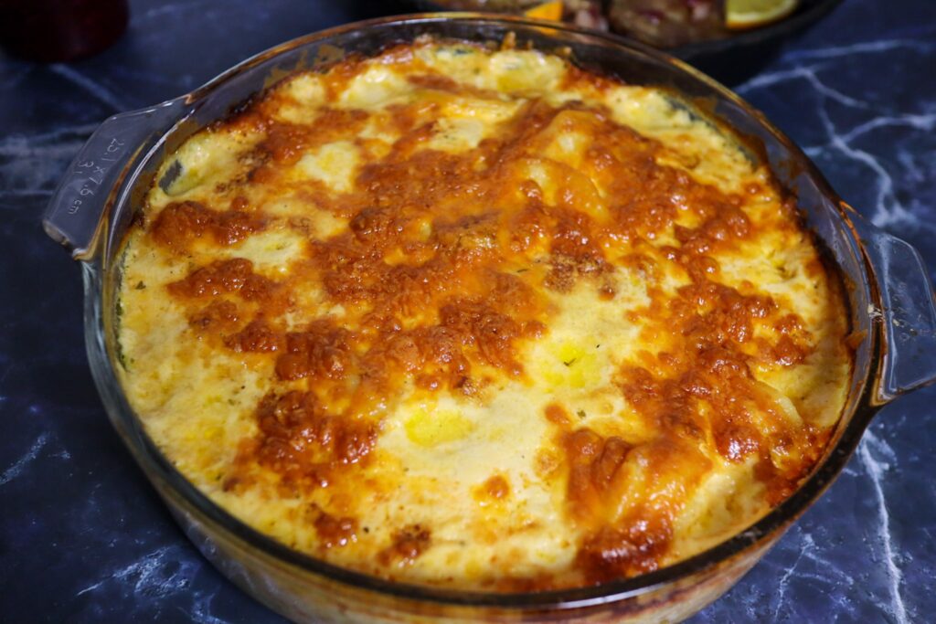 Scalloped potatoes with cranberry-glazed pork chops in the background.