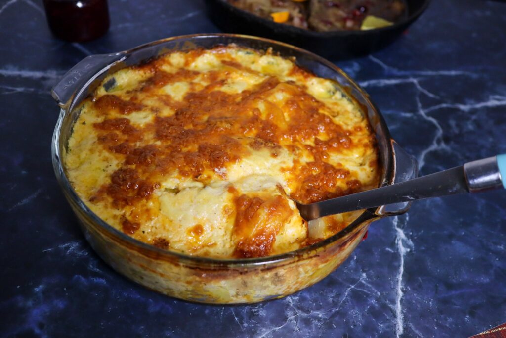 Scalloped potatoes with cranberry-glazed pork chops in the background.