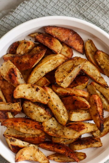 Roasted potato wedges in a serving dish.