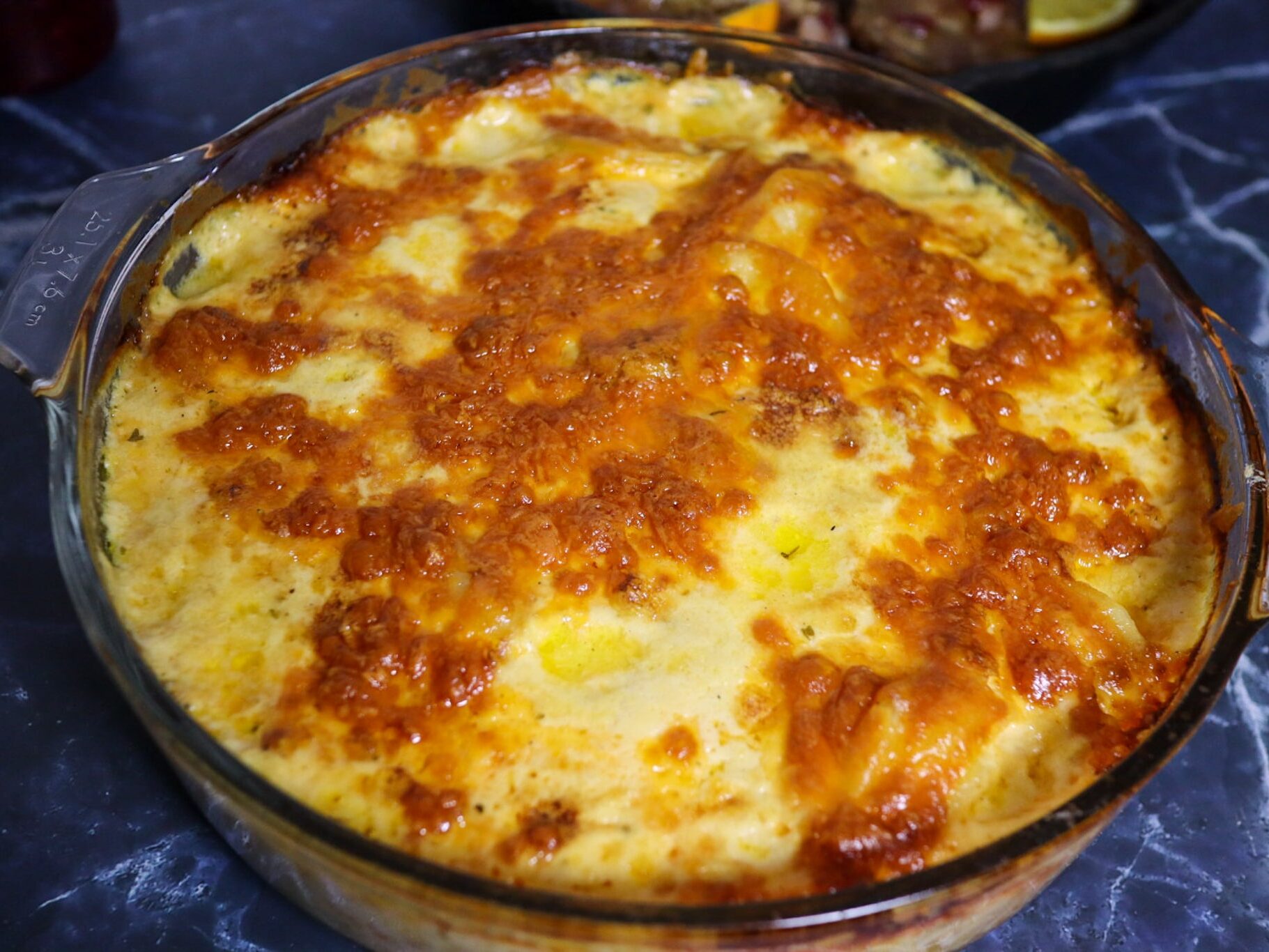 Scalloped potatoes with cranberry-glazed pork chops in the background.