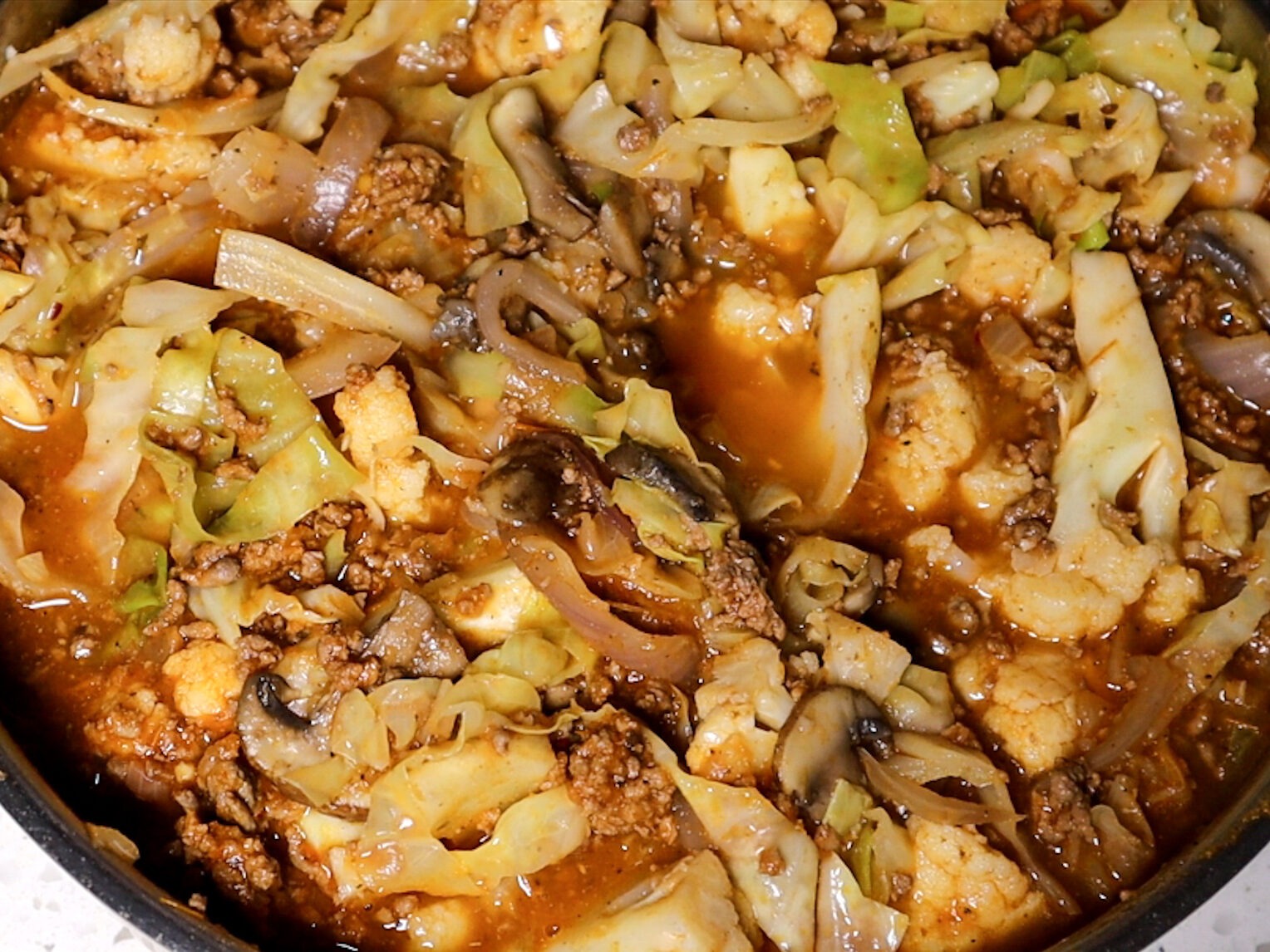 Combining the vegetables and meat sauce.